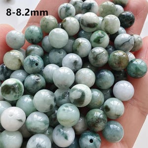 May include: A collection of round, polished beads in shades of green and white, with a diameter of 8-8.2mm. The beads have a marbled appearance and are suitable for jewelry making or crafting. The text "8-8.2mm" is visible in the upper left corner.