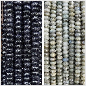 May include: Two strands of gemstone beads. One strand is black with a sparkly finish. The other strand is a light gray with a shimmery finish.