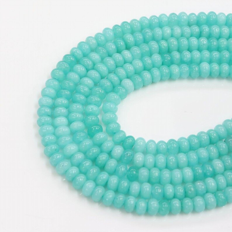 May include: A strand of turquoise blue round beads. The beads are smooth and have a slightly glossy finish.