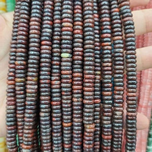 Pu&ograve; includere: Una collana di perline di pietre preziose rosse e marroni, ogni perlina &egrave; rotonda e ha una forma leggermente irregolare. Le perline sono infilate su un filo trasparente e sono pronte per essere utilizzate per la creazione di gioielli.