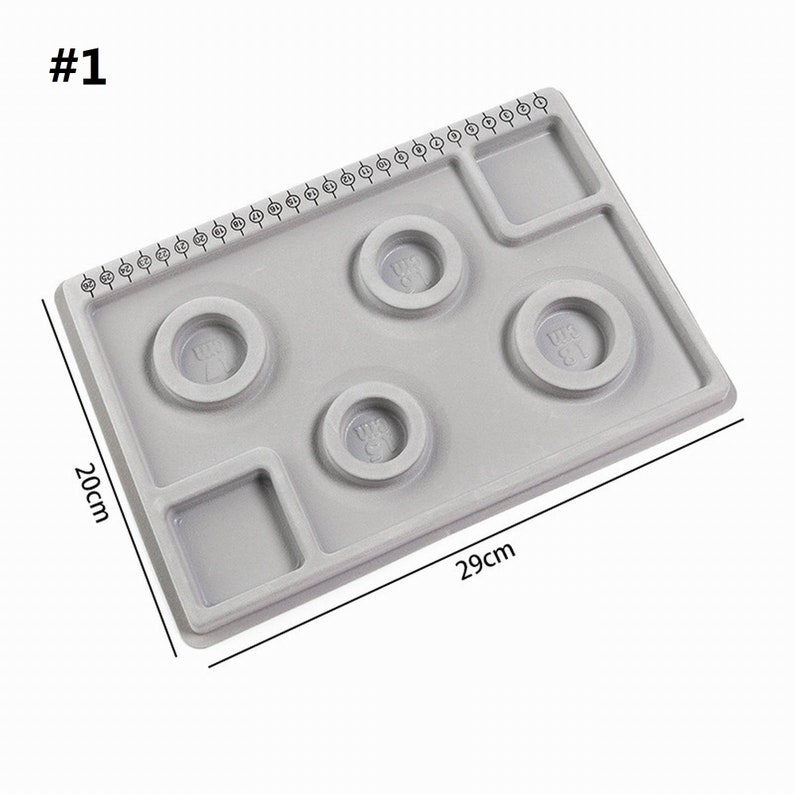 May include: Gray plastic ring sizing tool with four ring sizing circles and a ruler marked in sizes 1 to 40. The tool measures 29 inches by 20 inches.