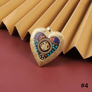 Puede incluir: Medall&oacute;n de coraz&oacute;n de oro con un dise&ntilde;o intrincado y colorido. El medall&oacute;n presenta un patr&oacute;n circular con acentos azules, rojos y dorados.