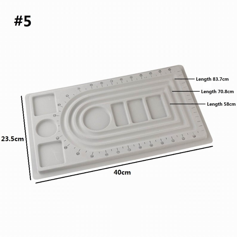 May include: White plastic jewelry making board with a ruler, circles, and squares for creating necklaces and bracelets. The board measures 23.5 inches by 40 inches.