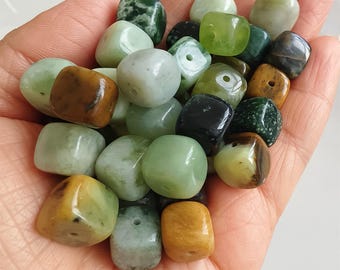 May include: A collection of green, brown, and black gemstone beads. The beads are cube-shaped and have a smooth, polished finish. They are perfect for making jewelry or other crafts.