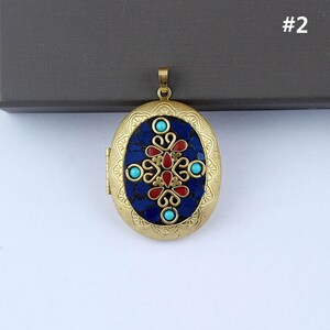 May include: Gold oval locket with a blue and red mosaic design. The locket has a floral pattern with turquoise accents.
