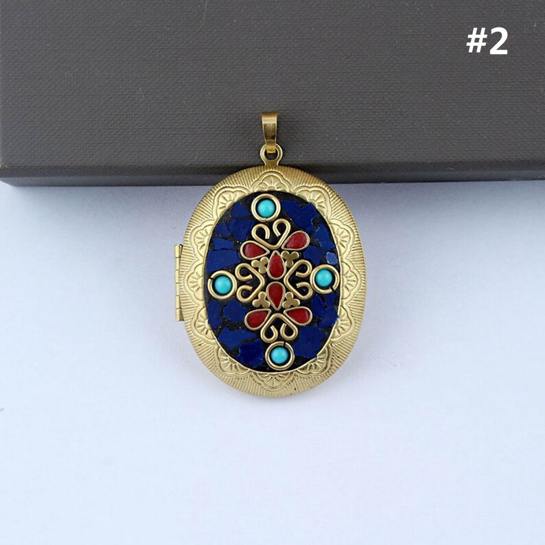 May include: Gold oval locket with a blue and red mosaic design. The locket has a floral pattern with turquoise accents.