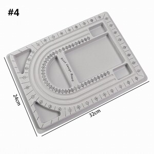 May include: Gray bead design board with a U-shaped groove for stringing beads. The board has a grid pattern with numbers for bead placement. It also has two small compartments for storing beads. The board measures 12.6 inches by 9.8 inches.