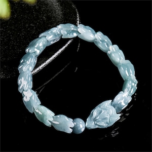 Puede incluir: Pulsera de jade azul claro con cuentas talladas en forma de flor y un cierre de cabeza de zorro. La pulsera est&aacute; ensartada en un cord&oacute;n oscuro. Una elegante pieza de joyer&iacute;a.