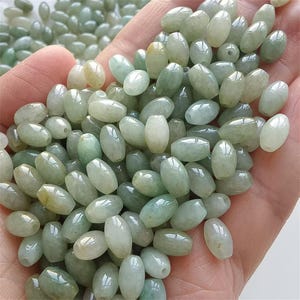 Può includere: Un pugno di perline di forma ovale nei toni del verde e del bianco. Le perline hanno una finitura lucida e lucida e sono infilate. Queste perline sono adatte per la creazione di gioielli.