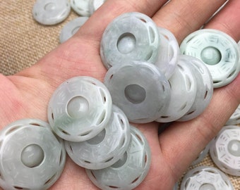 May include: A collection of jade green coin-shaped pendants with intricate carvings. Each pendant has a circular hole in the center and a raised design around the edge.