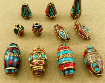 May include: Assortment of colorful, ornate beads with intricate designs. The beads are made of metal and feature turquoise, red, and gold accents.