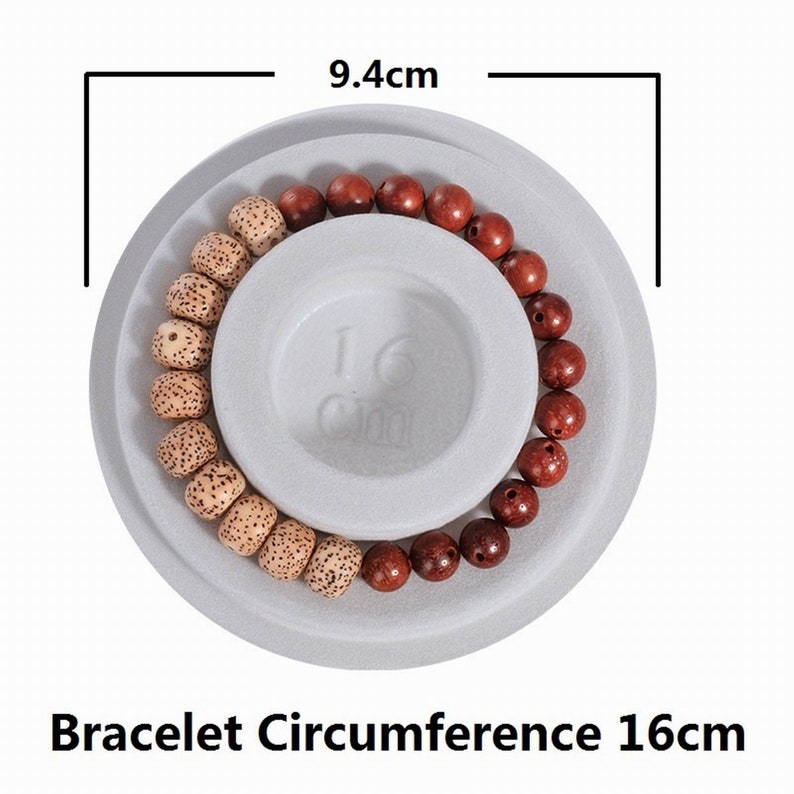 May include: A wooden beaded bracelet with brown and beige beads, displayed on a white circular platform with a 16cm diameter. The bracelet is 9.4cm in diameter.