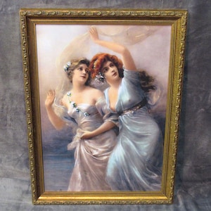 May include: A framed painting of two women in flowing white and blue dresses, with a light background. The women are holding a white fabric, and the painting has a vintage feel.