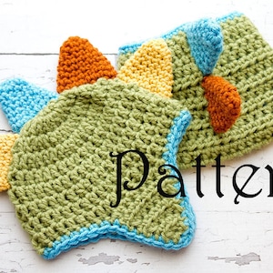 May include: A green, blue, yellow and orange crocheted dinosaur hat with the word "Pattern" written in black below it.
