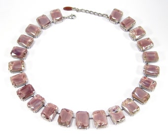 May include: A silver necklace with a row of rectangular, light purple, faceted stones.