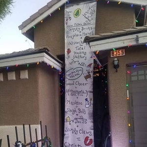 A house with a large Nightmare Before Christmas banner hanging from the roof, over the front door.