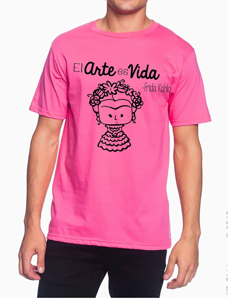 K&ouml;nnte beinhalten: Ein pinkfarbenes T-Shirt mit einer schwarzen Grafik von Frida Kahlo mit dem Text "El Arte es Vida - Frida Kahlo"