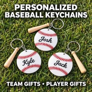 May include: Three personalized baseball keychains featuring white circular charms with red stitching and the names Josh, Kyle, and Jack in black script. Each keychain includes a small wooden baseball bat charm attached to a silver metal ring.