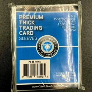 May include: A clear plastic package containing trading card sleeves. The package has a blue and white label with the words "PREMIUM THICK TRADING CARD SLEEVES". The label also includes the text "12 MIL POLYPROPYLENE 100 SLEEVES 2 3/4" x 3 3/4" FITS INSIDE TOPLOAD".