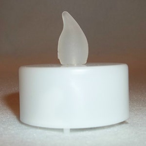 May include: A white, battery-operated tea light candle with a translucent, flame-shaped top. The candle has a cylindrical base and is designed to mimic the appearance of a real candle. Ideal for home decor and ambiance.