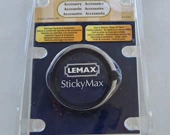 May include: A black and blue round container with the text "LEMAX StickyMax" on it. The container is packaged in a clear plastic clamshell with the text "Accessory Accessoire Accesorio Accessoire Accessoire Accessorio" on the front.