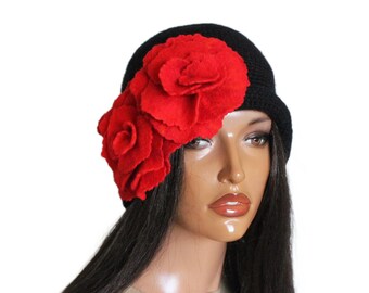 May include: A black knit hat with a large red felt flower embellishment.