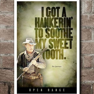 May include: A framed poster with a vintage aesthetic. The poster features a man in a cowboy hat holding a rifle, with the quote "I GOT A HANKERIN' TO SOOTHE MY SWEET TOOTH." The words "OPEN RANGE" are at the bottom.