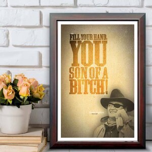 May include: Framed print with the text "FILL YOUR HAND. YOU SON OF A BITCH!" in a western-style font. The image includes a sepia-toned portrait of a man in a cowboy hat and eye patch. The frame measures 12"x18".