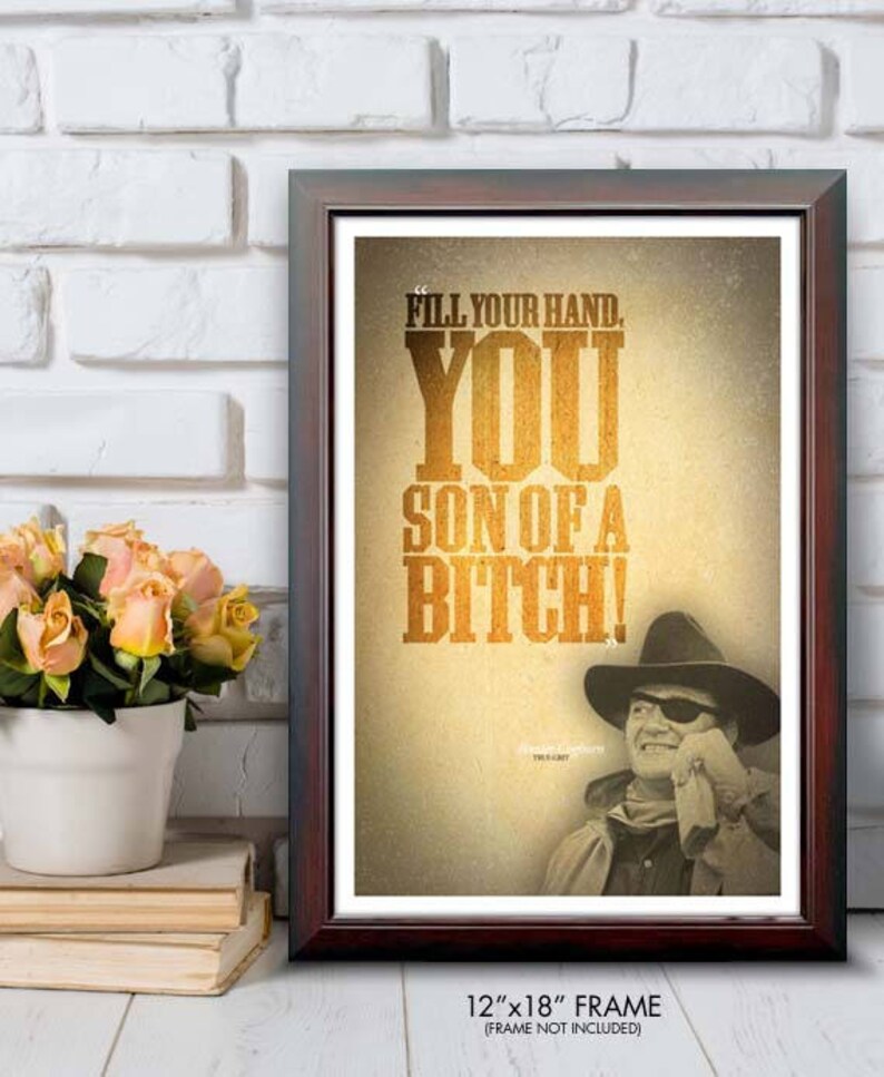 May include: Framed print with the text "FILL YOUR HAND. YOU SON OF A BITCH!" in a western-style font. The image includes a sepia-toned portrait of a man in a cowboy hat and eye patch. The frame measures 12"x18".