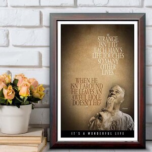 May include: Framed print with a quote from "It's a Wonderful Life." The text is in a brown font on a tan background, with a portrait of a man. The frame is dark brown, and the print is 12"x18".