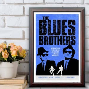 May include: Framed poster for "The Blues Brothers" movie. The poster features a blue background with the film's title in large black letters. Silhouettes of the two main characters are visible. The frame is 12"x18".