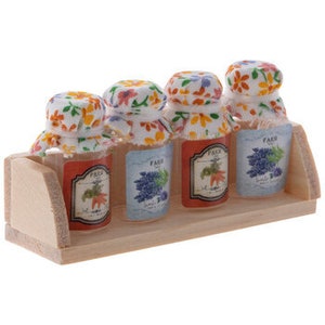 Bottiglie di gelatina di vetro in miniatura su miniature di decorazioni per casa delle bambole sullo scaffale