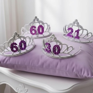 Tiara prateada com pedras prateadas brilhantes e pentes para um ajuste seguro. Escolha o número.