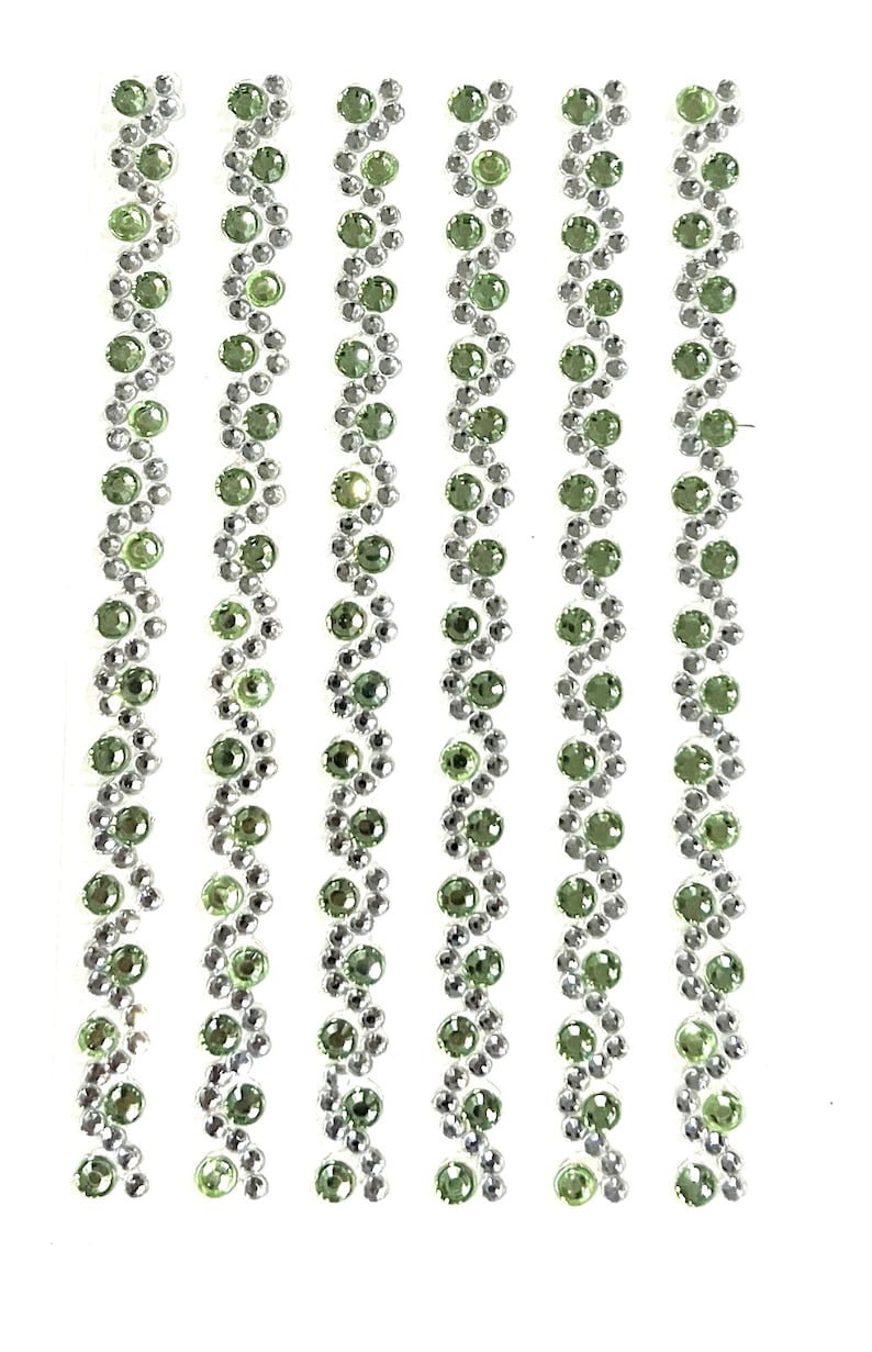 May include: Five rows of green and silver rhinestones arranged in a zig-zag pattern. The rhinestones are small and round.
