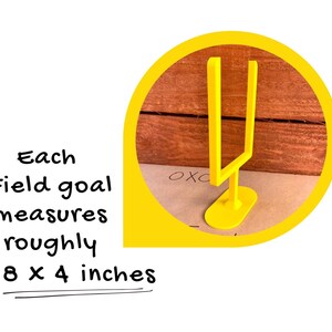 May include: A yellow field goal post, approximately 20 x 10 cm, is shown against a wooden background. The image is set within a yellow circle, with text indicating the dimensions of the goal post.