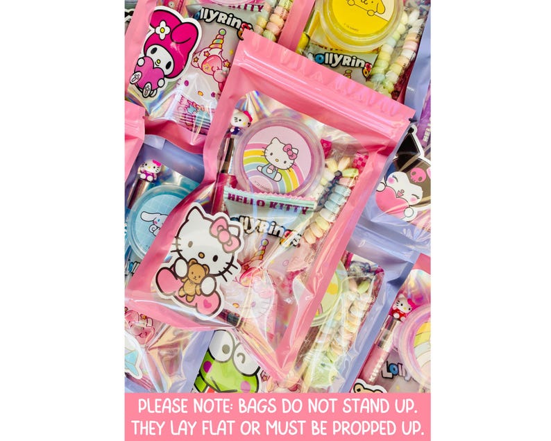 May include: Pink zippered bags filled with colorful candies and Hello Kitty-themed treats. The bags contain lollipops, stickers, and other sweets. The image includes text that reads "PLEASE NOTE: BAGS DO NOT STAND UP. THEY LAY FLAT OR MUST BE PROPPED UP."