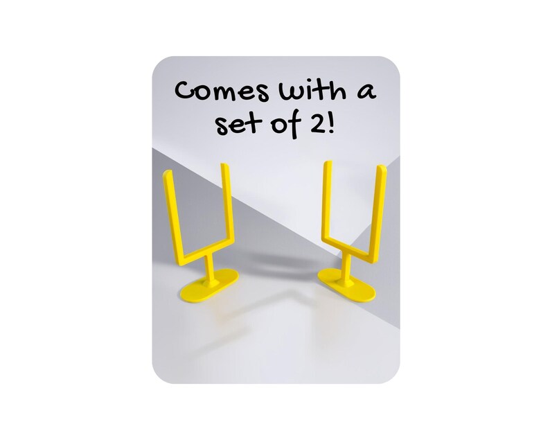 May include: Two yellow miniature football goal posts. The goal posts are on a white and grey background. The text "Comes with a set of 2!" is written in black above the goal posts.