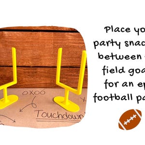 May include: Two yellow miniature football field goal posts on a brown surface with the word "Touchdown" and arrows. Text reads: "Place your party snacks in between the field goals for an epic football party!" A brown football is also shown.