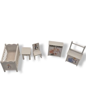 Può includere: Un set di mobili per la cameretta in legno bianco in miniatura. Include una culla, un tavolo, una sedia, un armadio e una sedia a dondolo. Ogni pezzo presenta illustrazioni di un coniglio. I mobili sono progettati per una casa delle bambole.