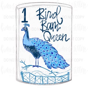 May include: A blue peacock illustration inside a clear glass. The peacock is perched on a branch above a fence. The text "1 Bird Bam Queen" is written in blue script.
