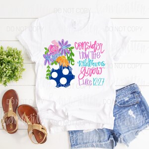 Pu&ograve; includere: Maglietta bianca con un disegno floreale e il testo "consider how the wildflowers grow Luke 12:27".