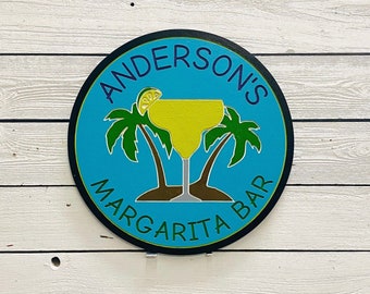 May include: A blue and white round sign with the text "Anderson's Margarita Bar" and a yellow margarita glass with a lime wedge and palm trees.