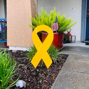 Letrero de madera con lazo amarillo para concienciar sobre el cáncer