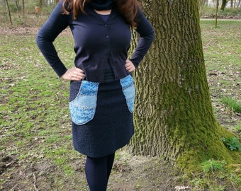 Women's skirt in blue made of curly fleece with blue cuffs and blue colored pockets with a flower pattern.