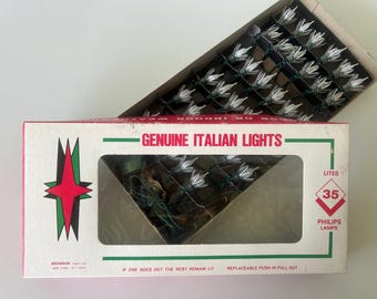 May include: A box of "GENUINE ITALIAN LIGHTS" with 35 Philips lamps. The box is white with a red and green starburst design. The lights are white and arranged in a grid.