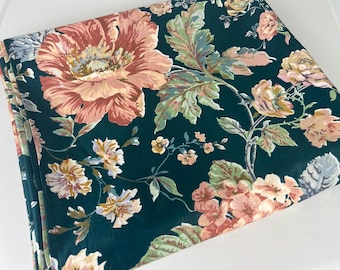 Puede incluir: Una tela verde oscuro con un patrón floral. Las flores son rosas, blancas y amarillas. La tela tiene una textura suave y lisa.