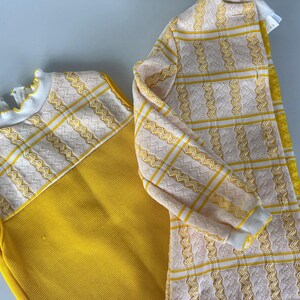 May include: A yellow sleeveless top with a white and yellow patterned trim, and a matching yellow and white patterned cardigan.