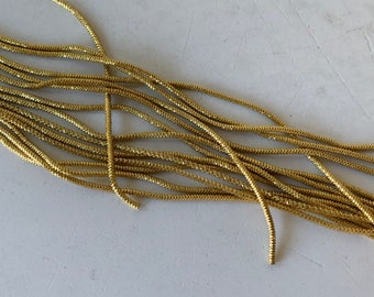 May include: A bundle of gold-colored, braided cord. The cord is approximately 1/8 inch thick and has a slightly textured surface.