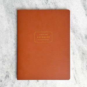 May include: A brown notebook with gold lettering that reads "Favorite Things Notebook" and "Making time for you".