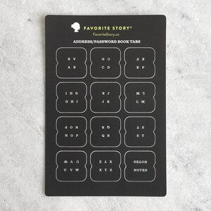 May include: Black address and password book tabs with white lettering. The tabs are labeled with letters of the alphabet and the word "NOTES". The text "FAVORITE STORY" and "FavoriteStory.co" are at the top.